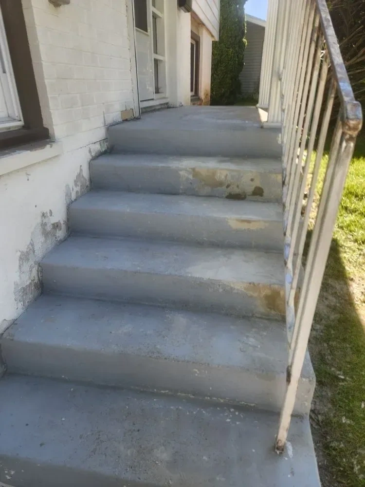 Worn peeling grey concrete exterior entryway stairs before painting - Scarsdale NY