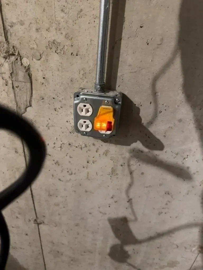 Surface mounted quad electrical receptacle and EMT conduit wired and circuit-tested on workshop masonry wall - Armonk NY