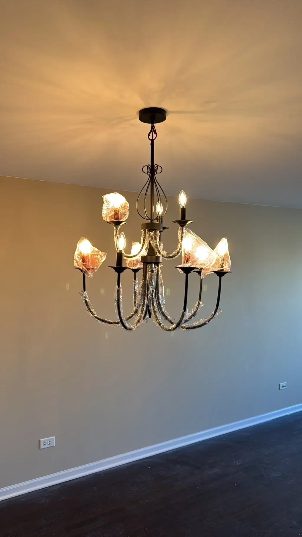 Modern matte black candle chandelier fixture installed, wired, and illuminated in dining room - Yonkers NY