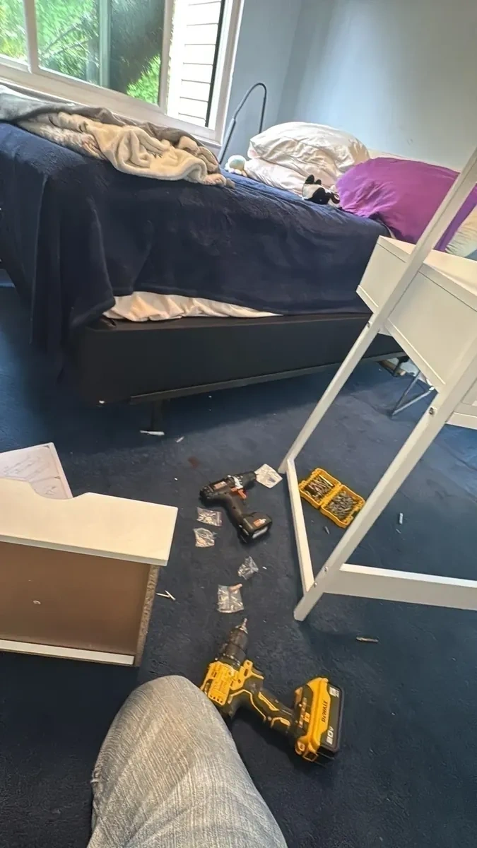 Flat pack desk panels unpacked on bedroom carpet with power tools before assembly - Chappaqua NY