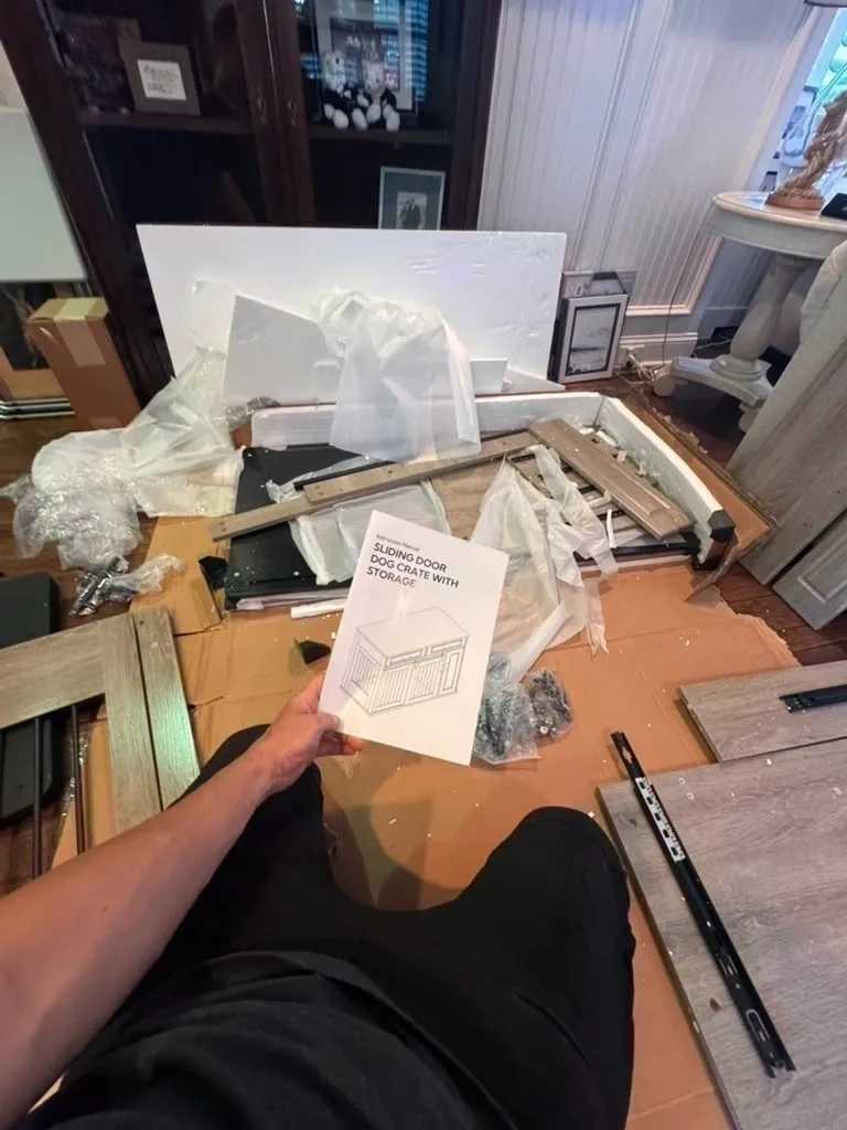 Unassembled sliding barn door dog crate furniture console parts and hardware on floor before assembly - Chappaqua NY