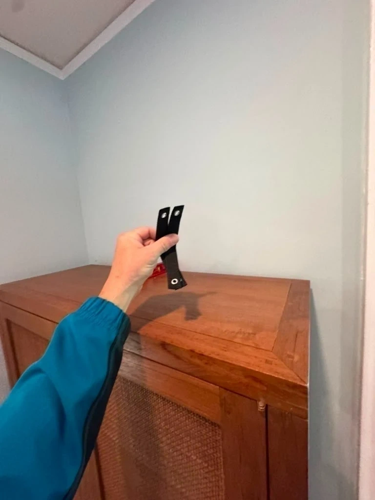 Heavy-duty nylon anti-tip safety strap held before wall stud anchoring - Hastings-on-Hudson NY