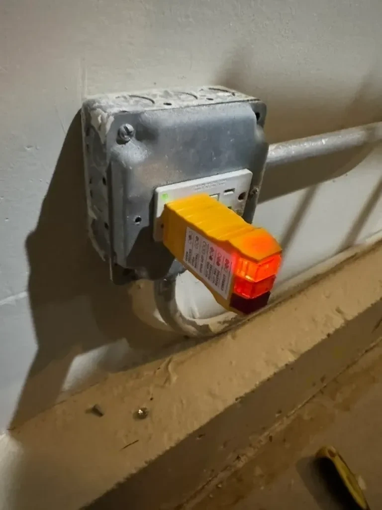 Smart GFCI electrical receptacle replaced, grounded, and verified with 3-wire circuit tester showing double amber lights - Scarsdale NY