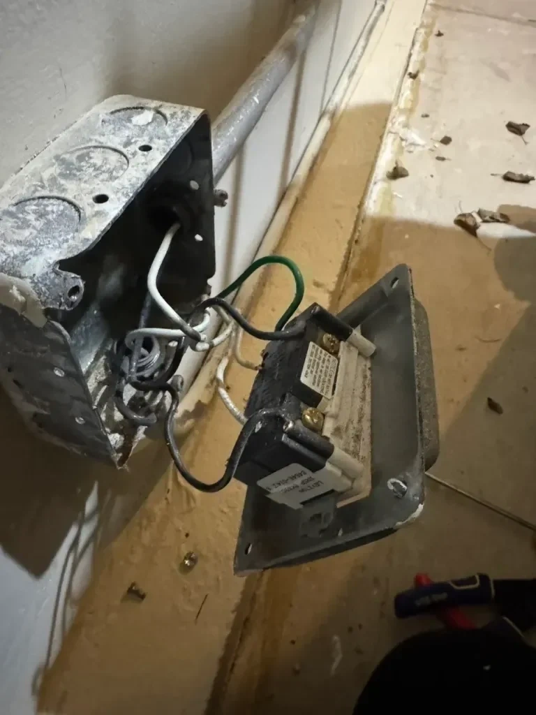 Open metal electrical junction box with hanging unbonded outlet wiring - Scarsdale NY