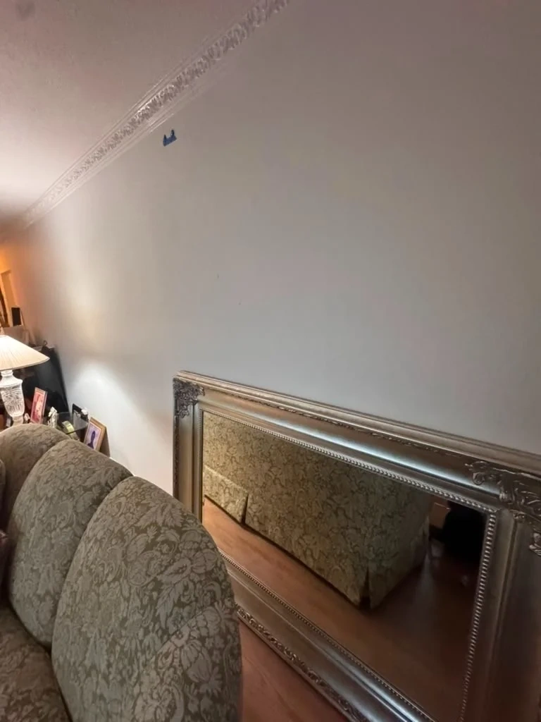 Heavy ornate silver framed mirror on floor with wall stud alignment markings - Harrison NY