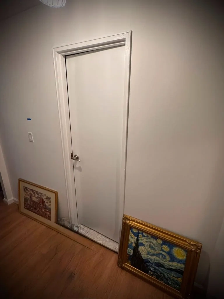 Heavy ornate gold framed artwork leaning against hallway floor before wall mounting - Scarsdale NY