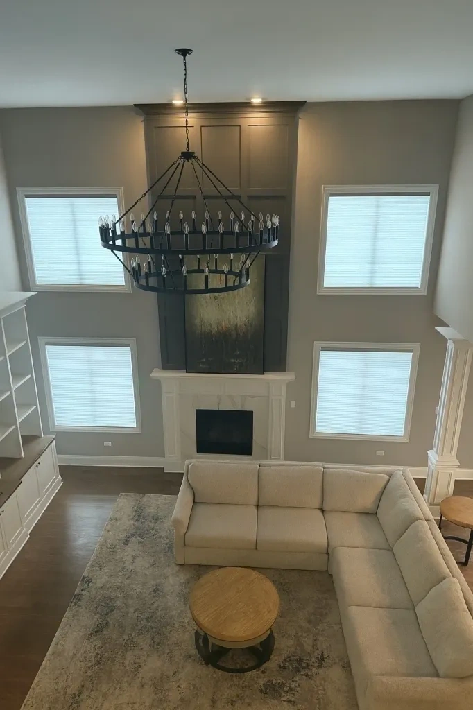 Two-story high ceiling living room with bare windows before curtain rod installation - Armonk NY