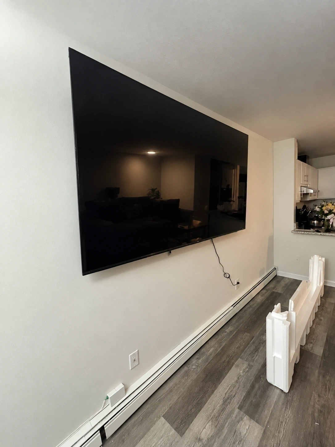 Large flat screen TV mounted level on living room wall with clean cable concealment - Tarrytown NY
