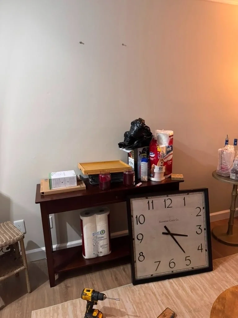 Decor wall clock resting on floor before wall mounting - Rye NY