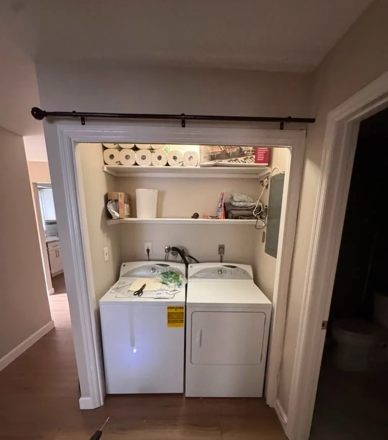 Black curtain rod mounted level above laundry closet door frame - Harrison NY