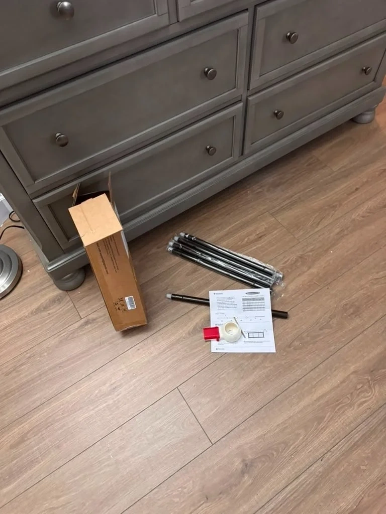 Unboxed curtain rod parts and manual on floor - Harrison NY