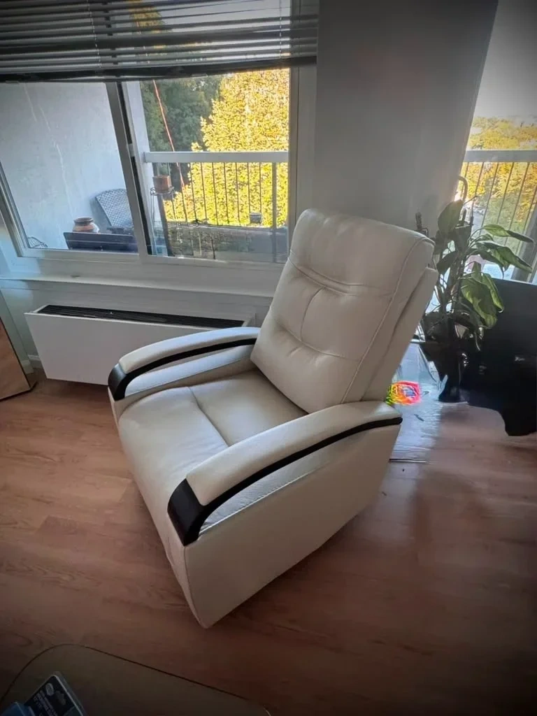 Assembled leather power recliner armchair positioned by living room balcony window - Rye NY
