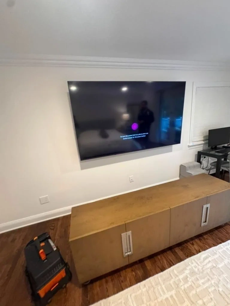 83 inch LG OLED evo C4 Smart TV mounted flush to wall above wooden media console - Scarsdale NY