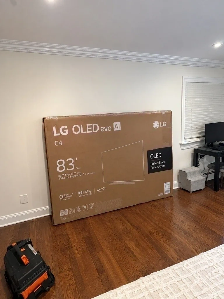 83 inch LG OLED evo C4 Smart TV box prepped on floor with tool bag for wall mounting - Scarsdale NY