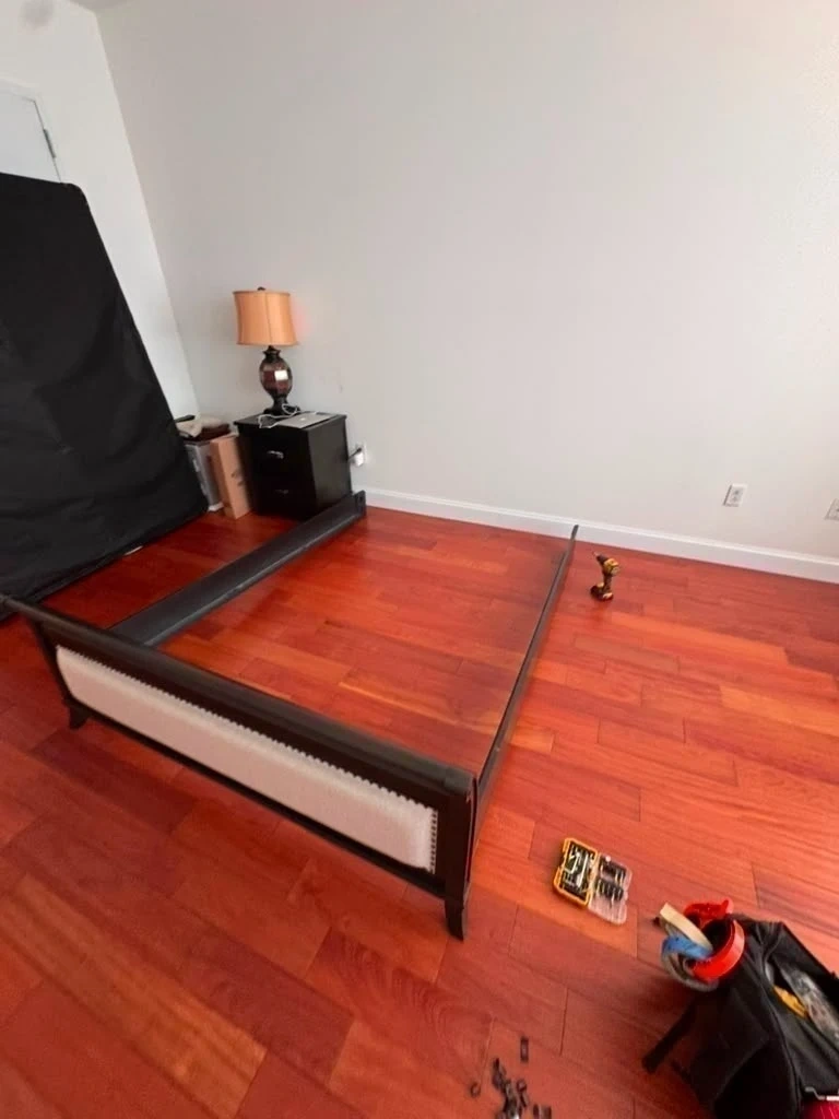 Bed frame side rails, footboard, power tools, and hardware prepped on hardwood floor - Purchase NY