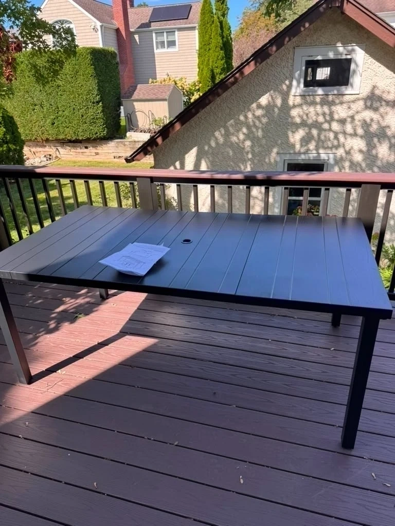 Assembled black metal slatted outdoor patio dining table on composite deck - Harrison NY
