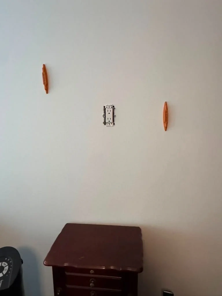 Recessed wall power outlet installed level between stud markers above bedroom console - Scarsdale NY