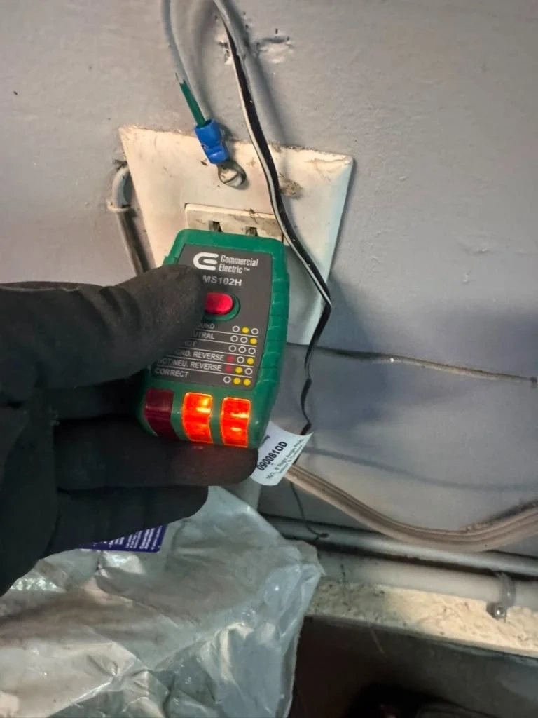 Multimeter voltage testing on garage GFCI circuit before Ring floodlight camera installation