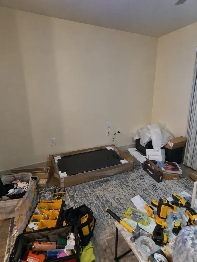 Unboxed Roku Smart TV on rug with DeWalt tools prepped for wall mounting - Dobbs Ferry NY