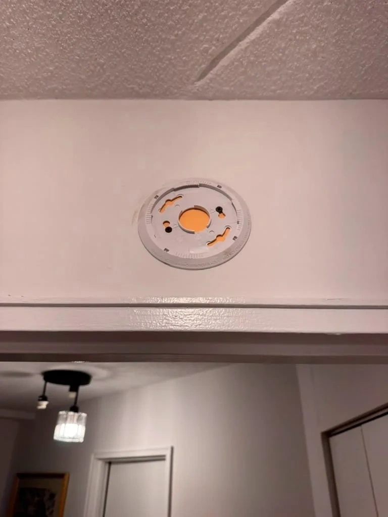 Ceiling ring plate mounted flush above door trim for Kidde smoke detector - Scarsdale NY