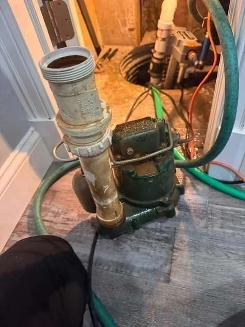 Old failed sump pump removed from pit with stained PVC - Scarsdale NY