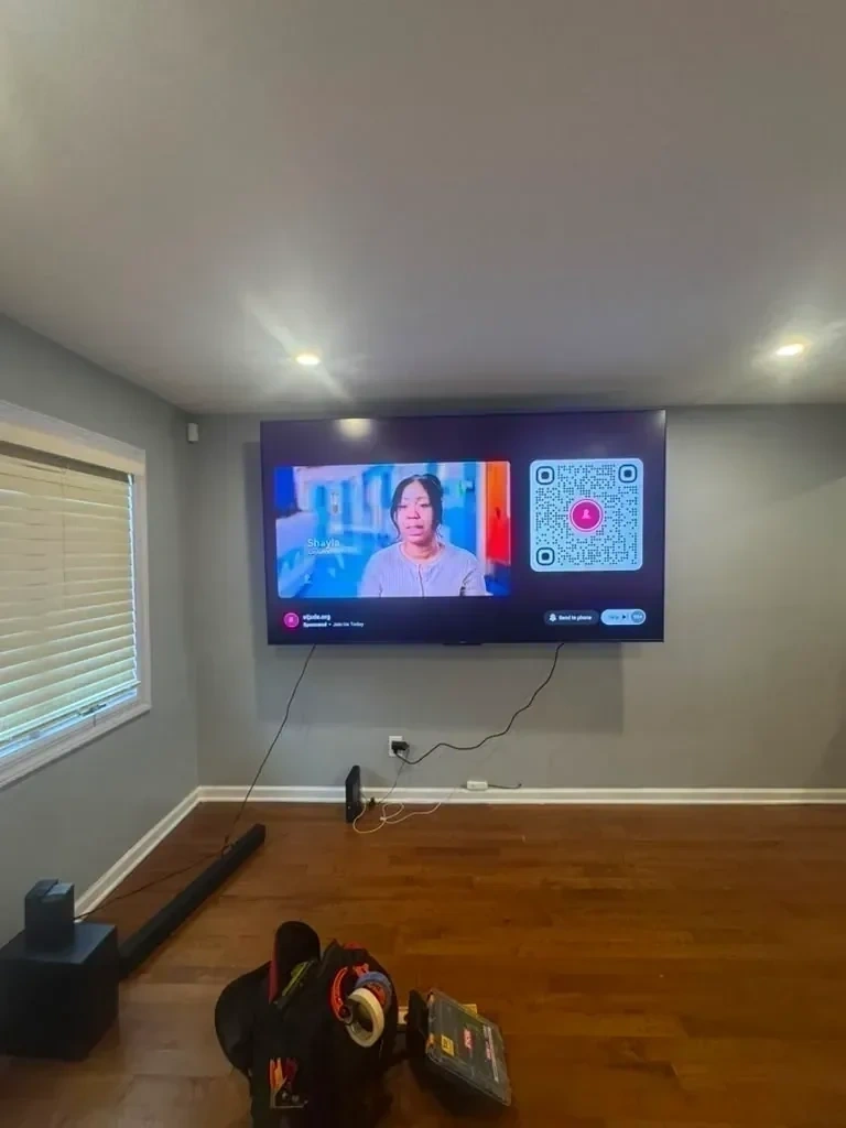Large flat screen TV mounted level on wall and powered on - Larchmont NY