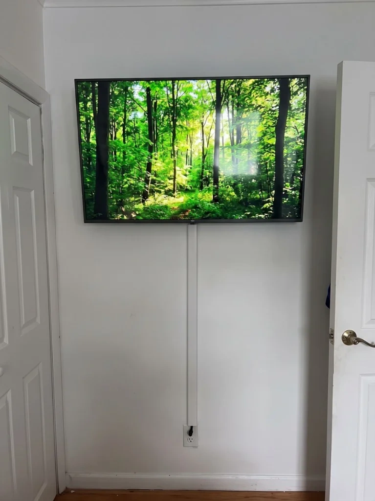 Clean TV wall mount with white cable concealer raceway and 4K display - Chappaqua NY