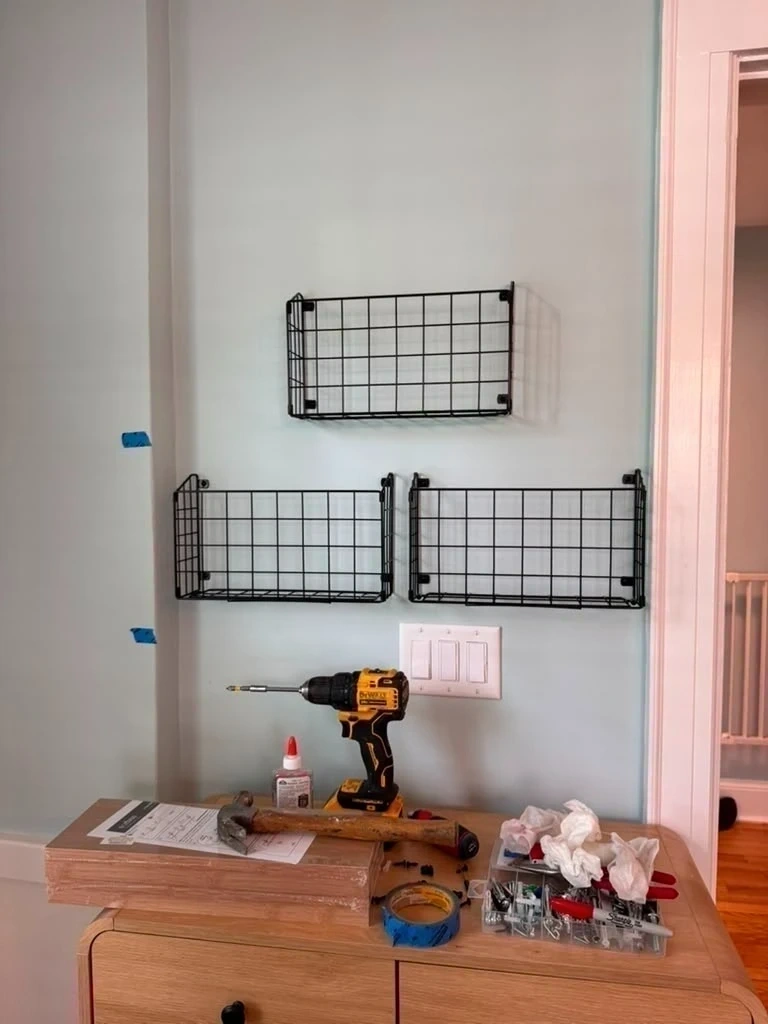 Three black wire storage baskets leveled and anchored to entryway wall - Hastings-on-Hudson NY